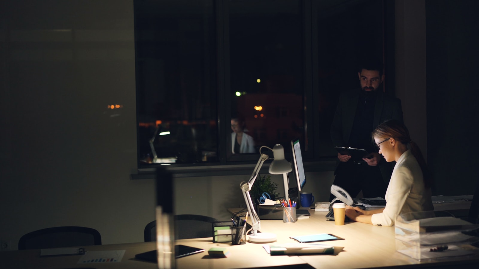 Staff working through the night in a dimly lit workplace
